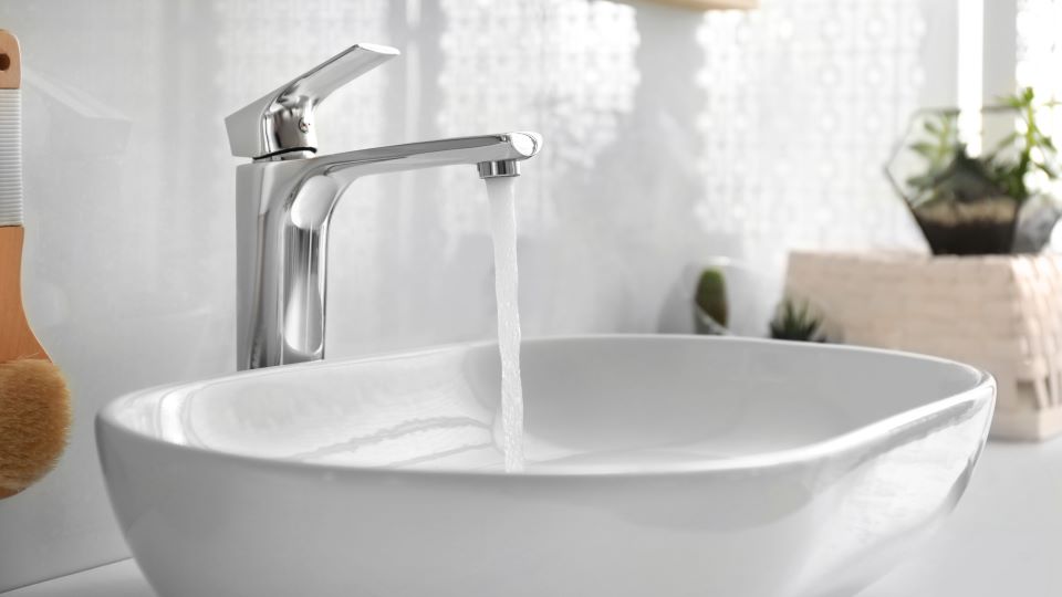 Waschbecken mit laufendem Wasserhahn